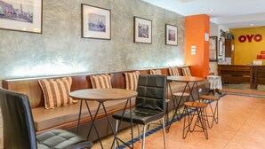 A hotel lobby with a seating area, framed pictures on the wall, and a reception desk. - Sunshine House (Chiang Mai)