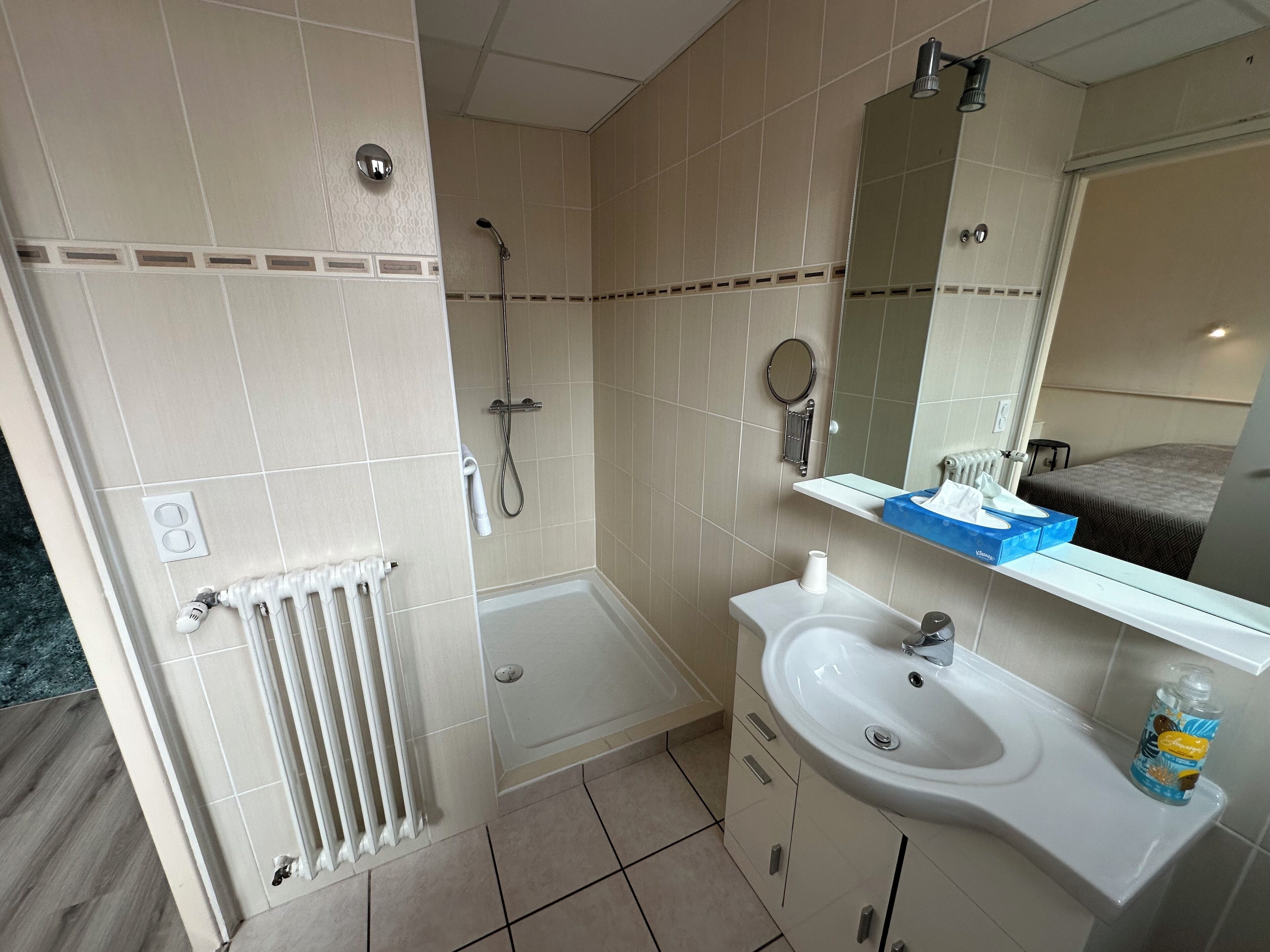 Un baño con bañera, lavamanos, espejo y ducha.