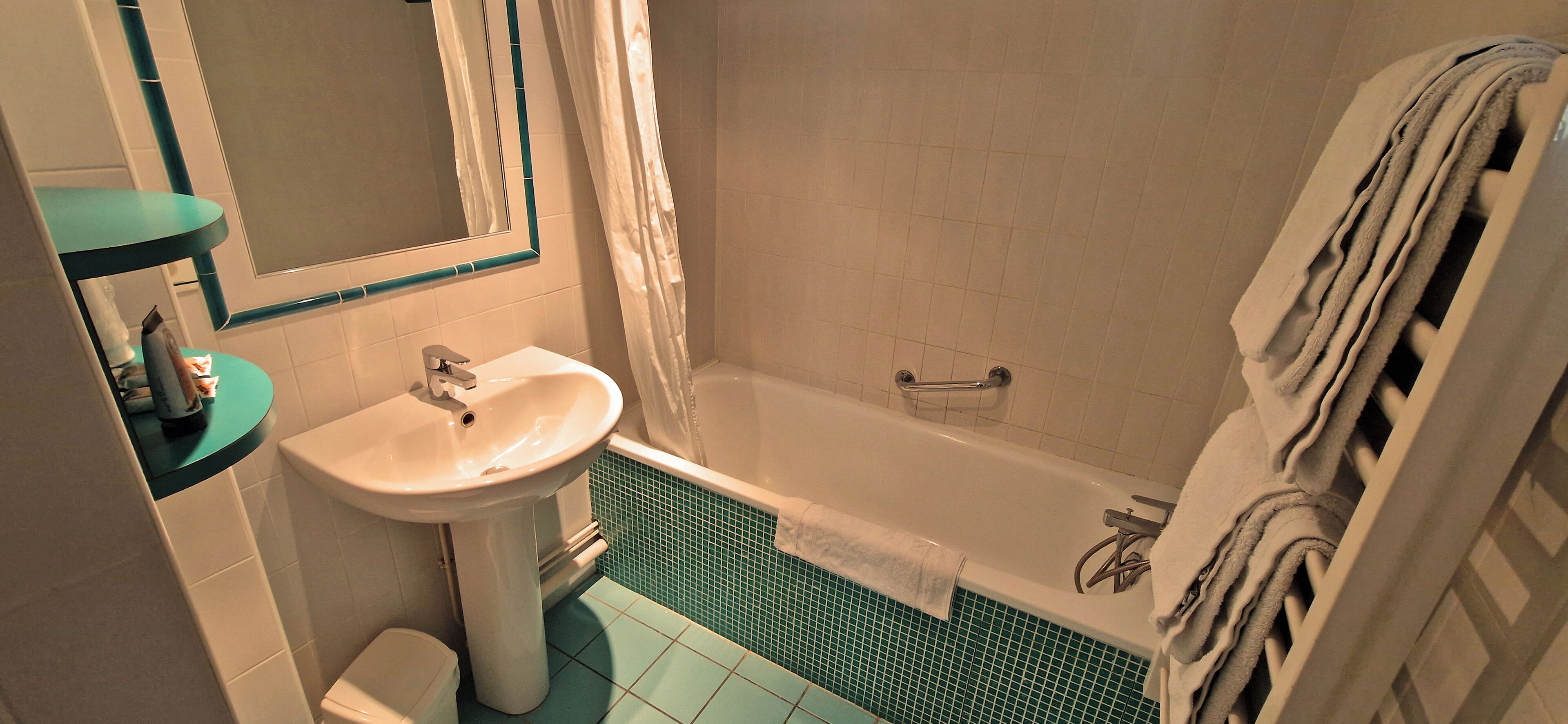 A bathroom with a sink, toilet, bathtub, and a towel rack.