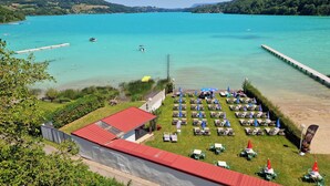 Un hotel junto al lago con terraza y vistas al lago.