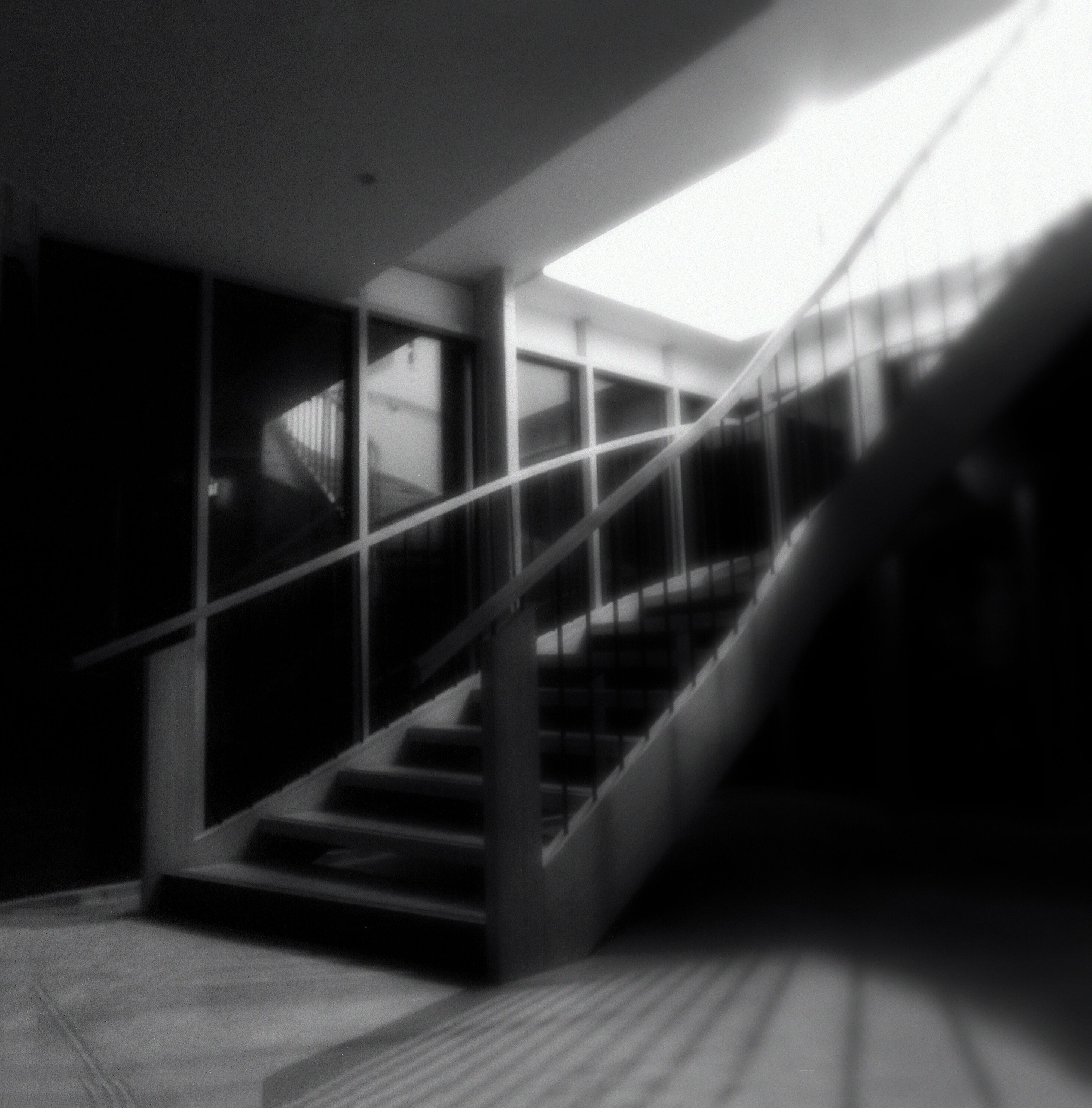 A staircase with glass railings leading to an upper floor.