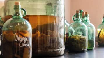 Un ensemble de récipients en verre, chacun portant une étiquette, et dont certains contiennent des parfums d’orange et de potiron, disposés sur une surface.
