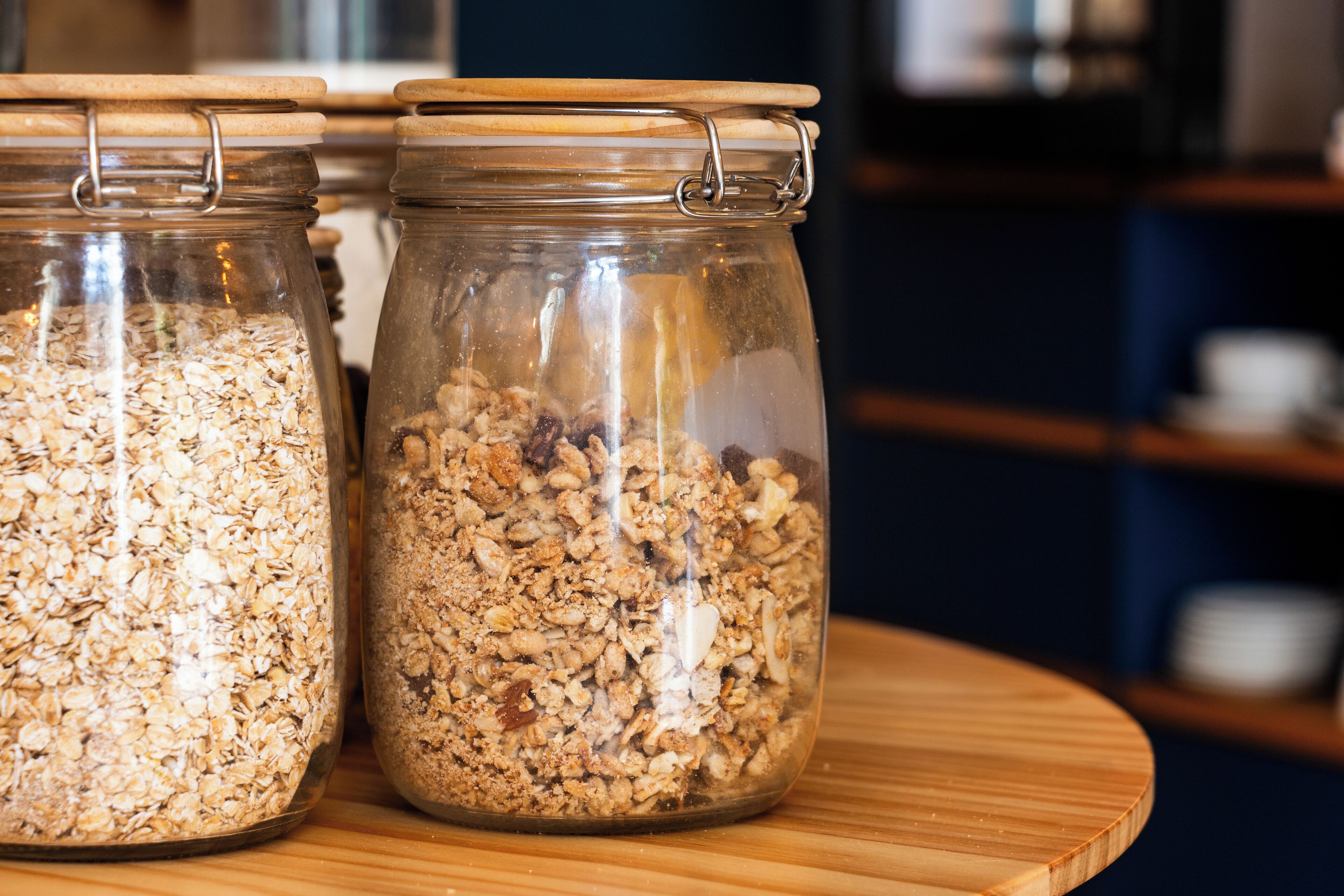 Two glass jars with metal lids on a wooden surface.