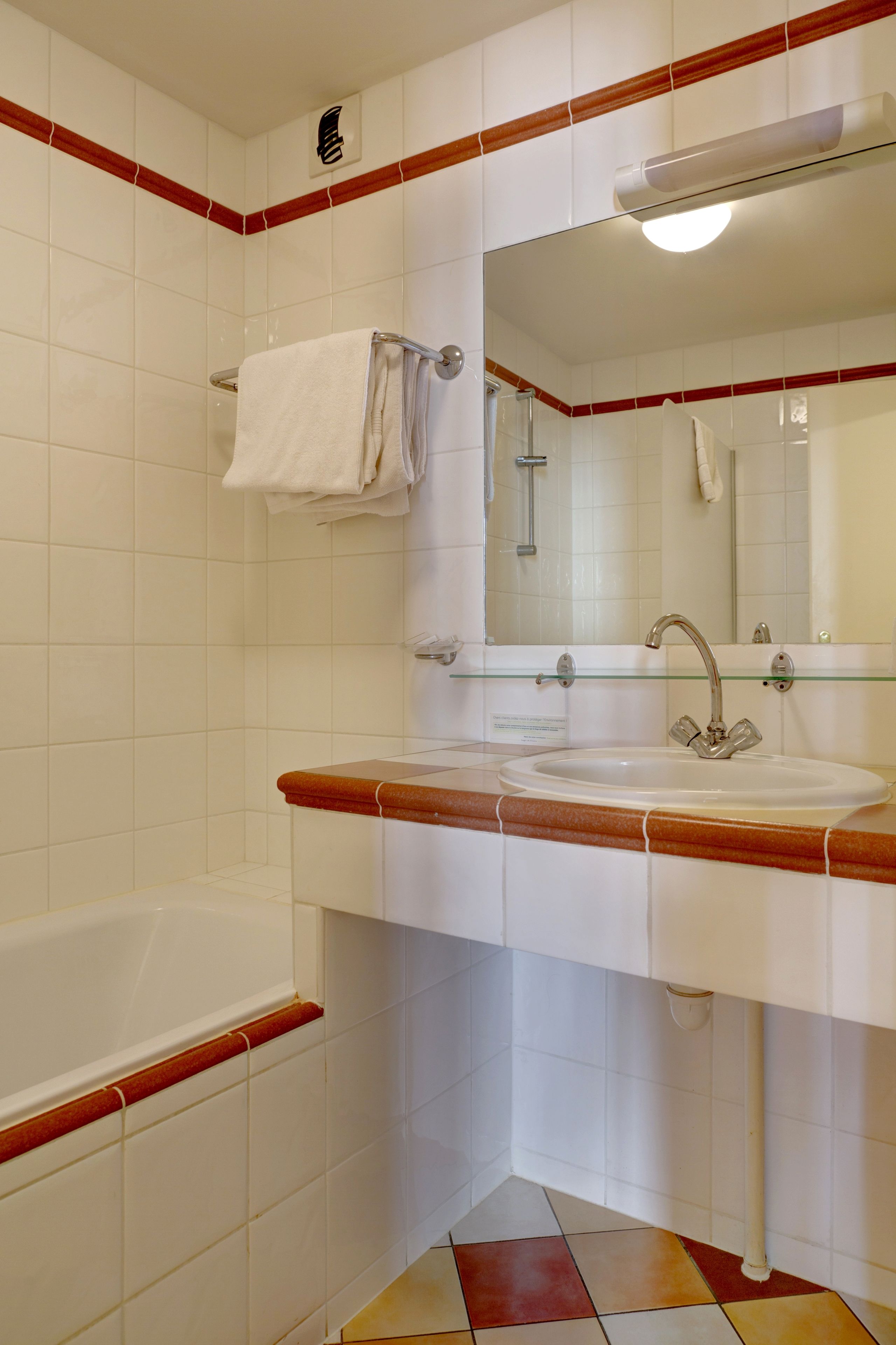 Een badkamer met een bad, een wastafel en een spiegel.