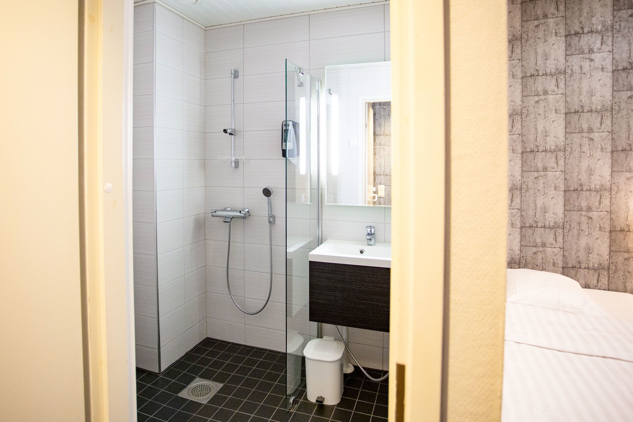 Un baño con ducha, lavamanos e inodoro.