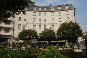 Un hotel con un cartel que dice "Grand Hotel de la Gare" y un café llamado "Brasserie de la Gare" en primer plano.