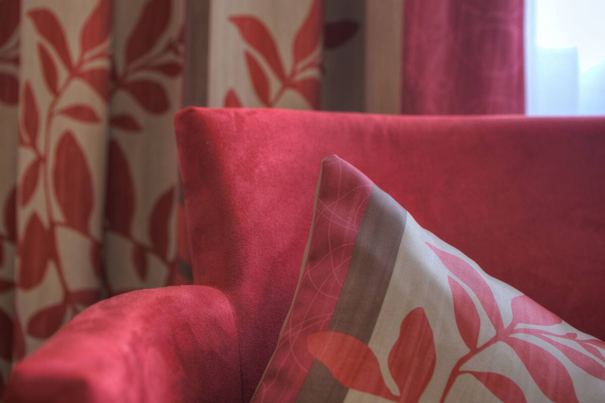 A close-up of a red upholstered chair with a floral pattern.