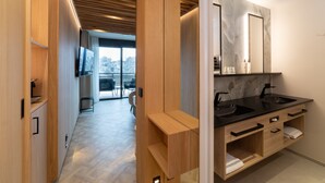 A modern bathroom with a black sink, wooden cabinetry, and a large mirror.