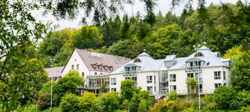 Un hotel con varias construcciones, rodeado de abundante follaje y árboles.