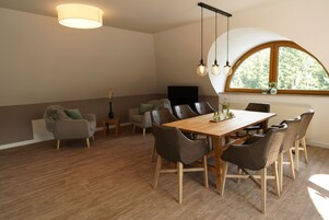 Un comedor con mesa y sillas de madera, un sofá y un televisor.