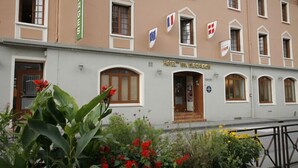 Een hotelgebouw met veel ramen en vlaggen, waaronder de Europese vlag en de Deense vlag.