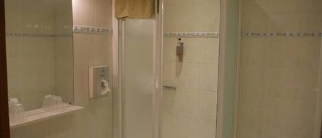A bathroom with a glass-enclosed shower, a sink with a towel, and a toilet.