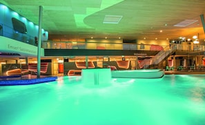 Piscina coperta a più livelli dal design moderno, con una scala a vista e una zona relax.