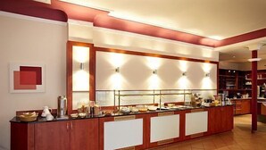 A buffet area with a long counter, multiple food stations, and overhead lighting. - BSW - Hotel Lindenbach (Nievern)