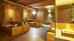 A spa room with wooden furniture, a brick wall, and a fireplace. - Schlosshotel Braunfels (Braunfels)