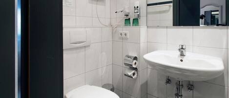 Un baño pequeño con inodoro, lavamanos y espejo.