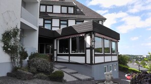 Ein zweistöckiges Haus mit Balkon und überdachter Veranda.