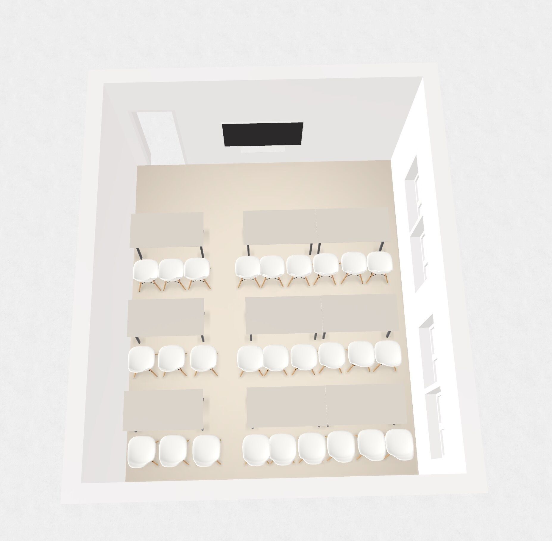 A room with a white ceiling, multiple white chairs arranged in rows, and a black rectangular object on the ceiling.