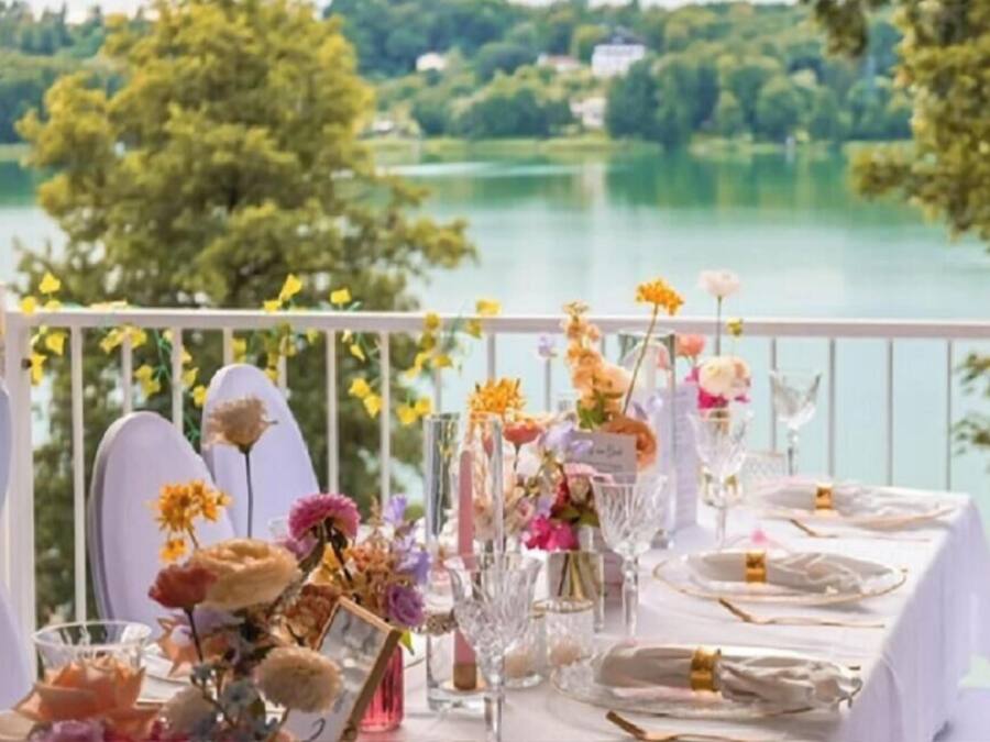 A table set for a meal with a view of a lake and trees.