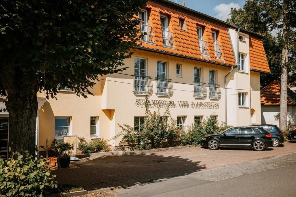 A two-story building with a yellow facade and orange roof tiles.