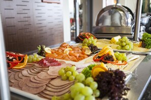 A buffet with various food items including meats, cheeses, and fruits. - PHÖNIX Hotel (Bergneustadt)