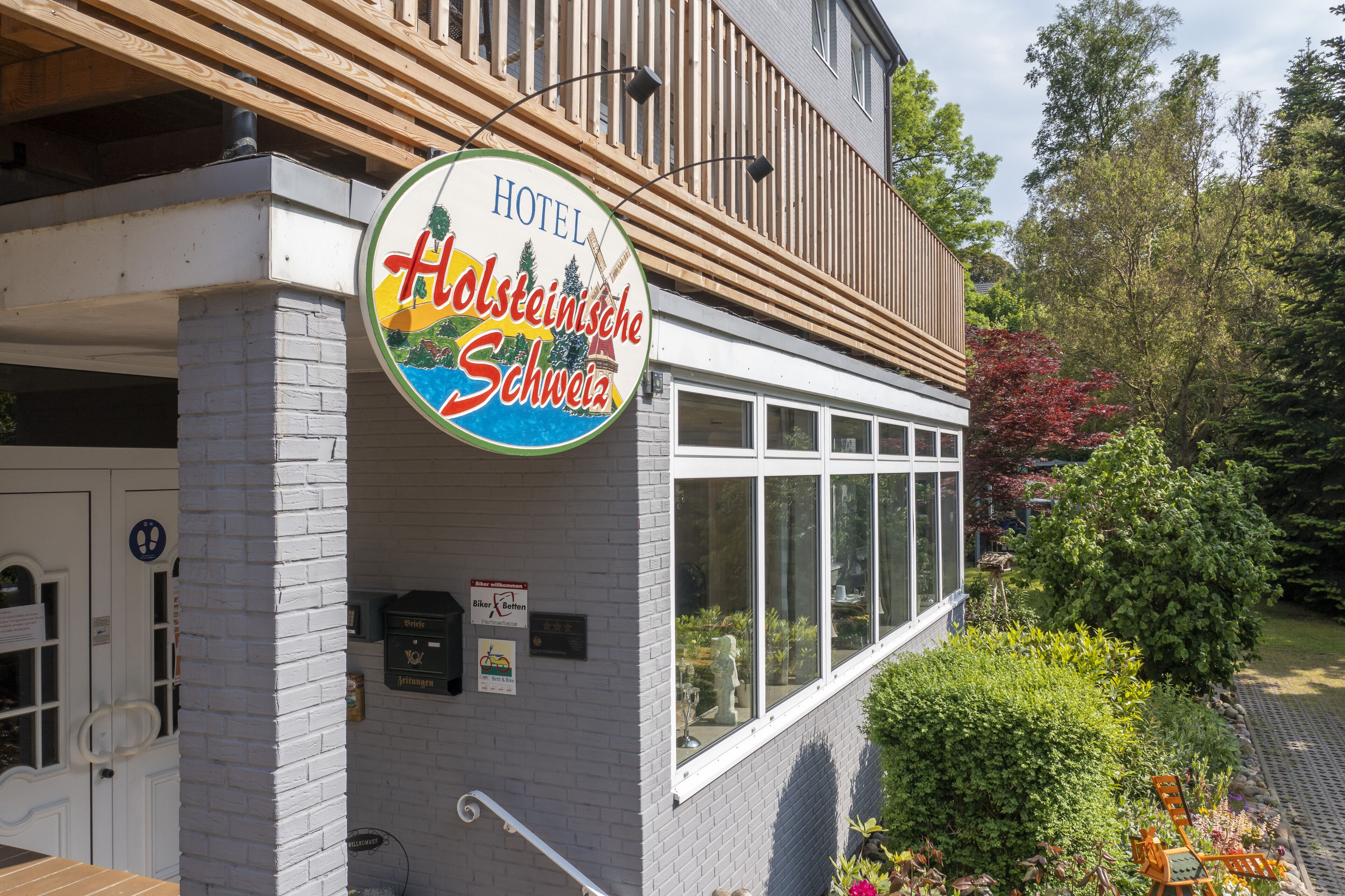Exterior de un hotel con un letrero que dice 'HOTEL Holsteinische Schweiz'.