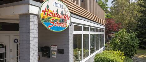 Exterior de un hotel con un letrero que dice 'HOTEL Holsteinische Schweiz'.