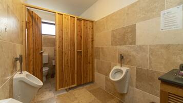 Herren-Toilette mit Holztrennwänden, Urinal und WC.