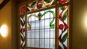 A stained glass window with floral patterns. - Hotel Xantener Eck (Berlin)