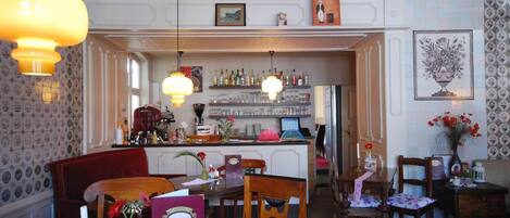 Un comedor con una barra al fondo, muebles de madera y objetos decorativos en las paredes.