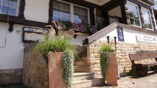 Un edificio con fachada de piedra, vigas de madera y un letrero para un restaurante.