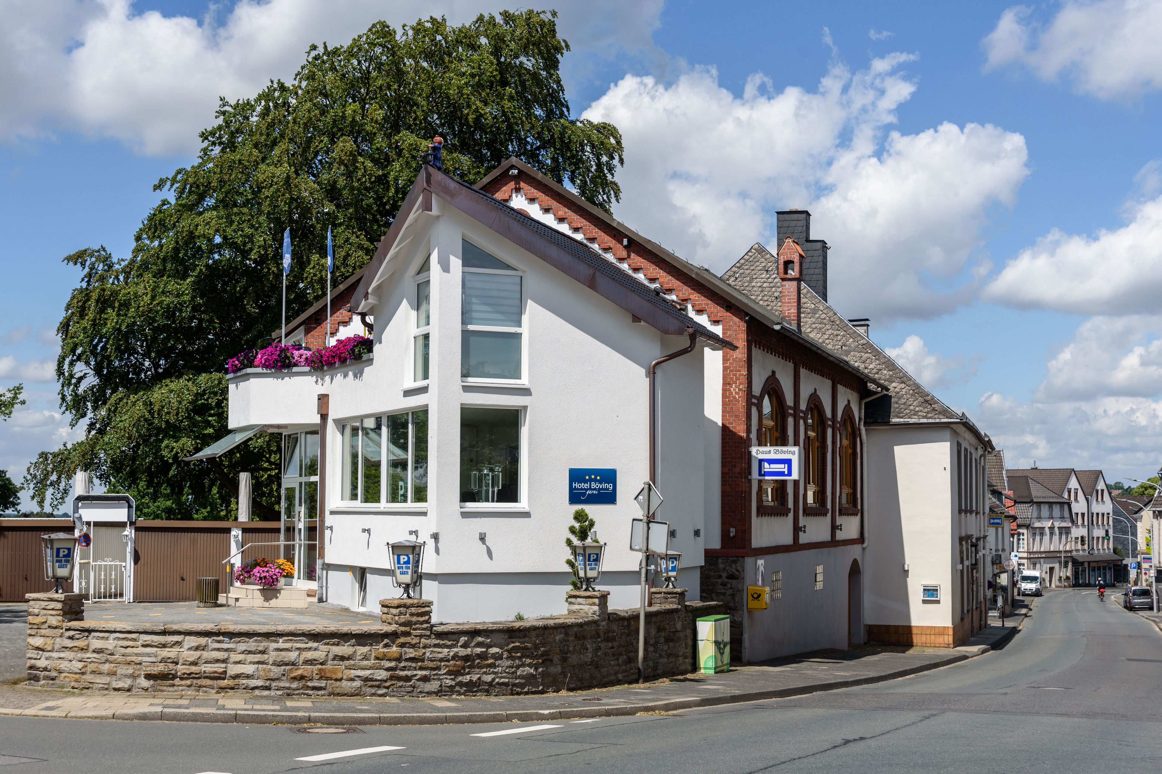 Un bâtiment blanc avec une enseigne indiquant qu’il s’agit d’un hôtel.