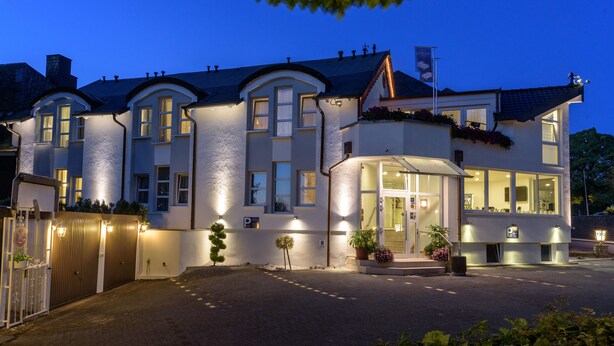A large, well-lit hotel with multiple windows and a gated entrance. - Hotel Boeving (Breckerfeld)