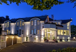 A large, well-lit hotel with multiple windows and a gated entrance. - Hotel Boeving (Breckerfeld)