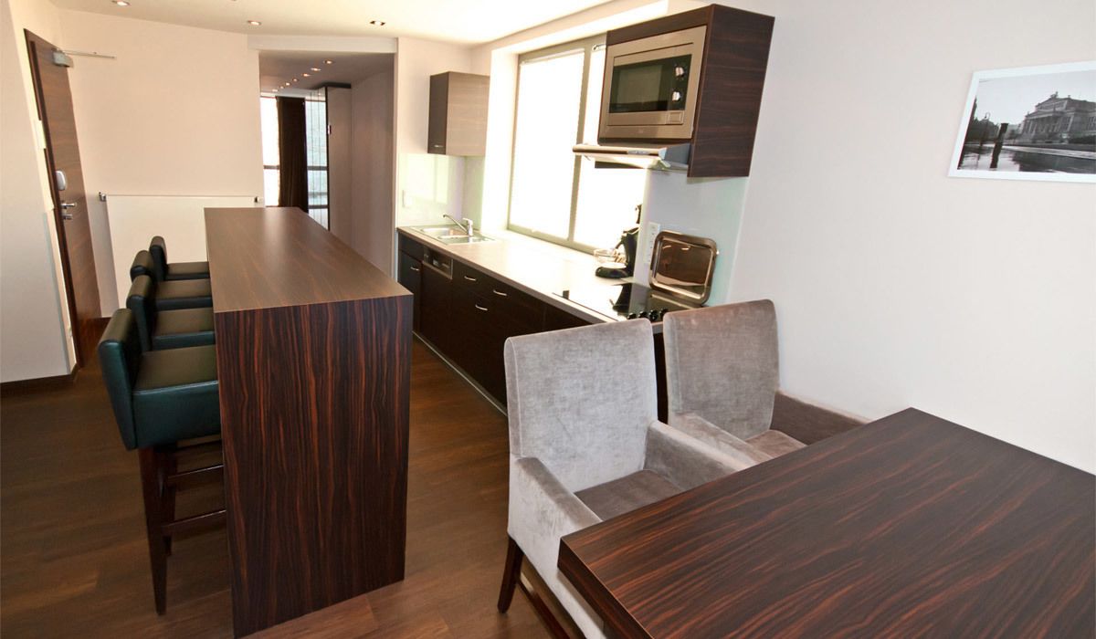 Una cocina moderna con armarios de madera oscura, un microondas integrado y un amplio ventanal.