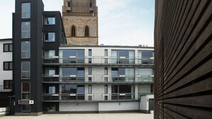 A modern building with a stone tower, multiple balconies, and a sign reading "EINGANG". - Boardinghouse Bielefeld (Bielefeld)