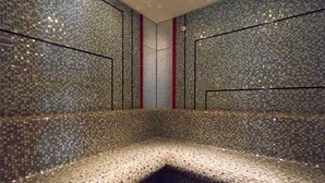 A mosaic-tiled sauna with a bench and a central column. - Le Domaine Des Chevaliers De Malte Hotel (Villedieu-les-Poêles-Rouffigny)