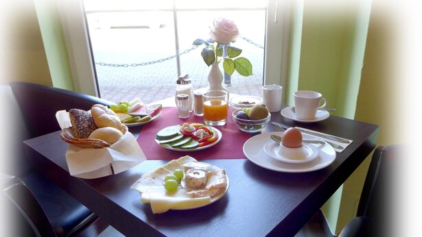 A breakfast table with various foods, including bread, cheese, and fruit. - Hotel Lindenberger Hof (Ahrensfelde)