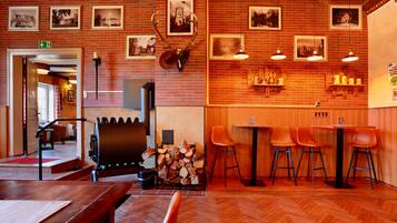 Un restaurante con paredes de ladrillo, muebles de madera y cuadros en las paredes.