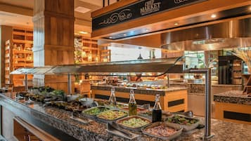 Ett område med en buffé och olika matstånd, samt en skylt med texten ”CHEF MARKET GRAND CAFE & DECK”.