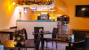 A bar area with a counter, seating, and a coffee machine. - Hotel Arcangelo - Salina (Santa Marina Salina)