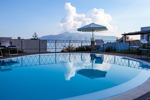 En säsongsöppen utomhuspool, infinity-bassäng, parasoller och solstolar