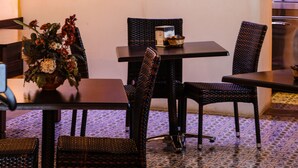 A restaurant with a bar area, tables, chairs, and a coffee machine. - Hotel Arcangelo - Salina (Santa Marina Salina)