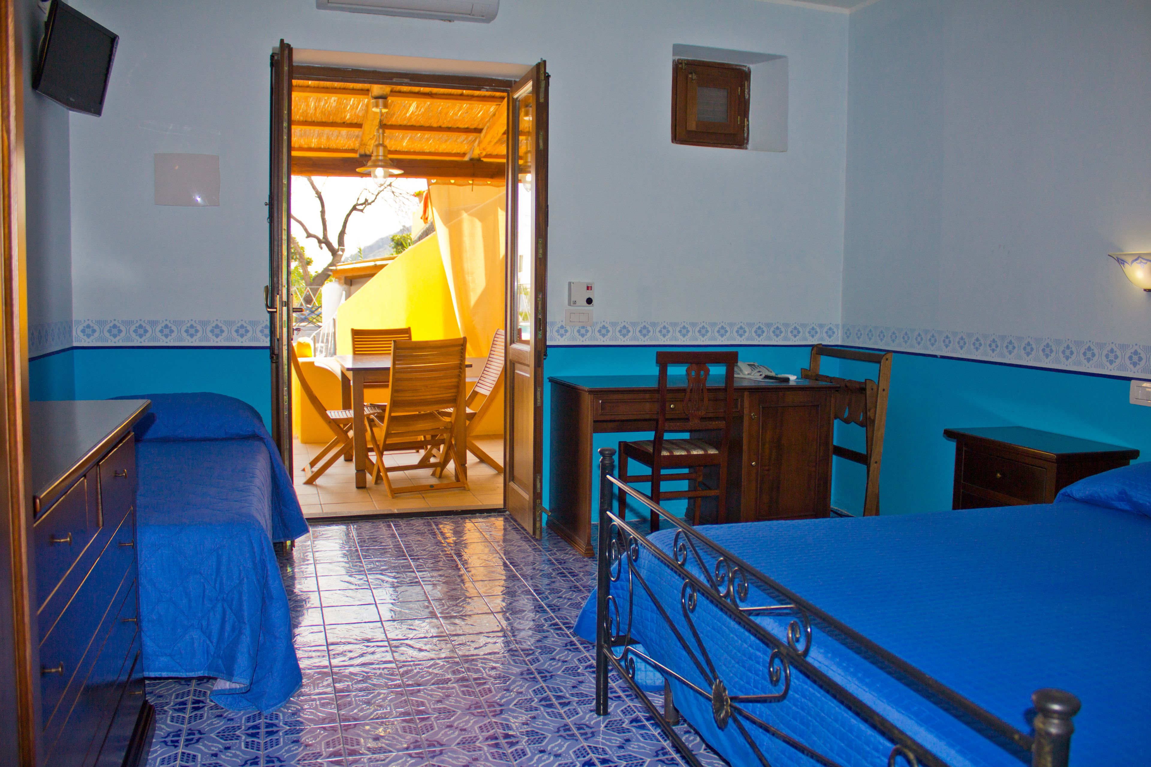 A room with a bed, a desk, and a chair.