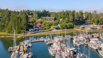 A marina with numerous boats docked, surrounded by lush greenery and residential buildings.