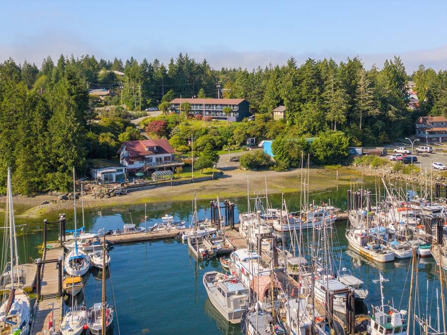A marina with numerous boats docked, surrounded by lush greenery and residential buildings.
