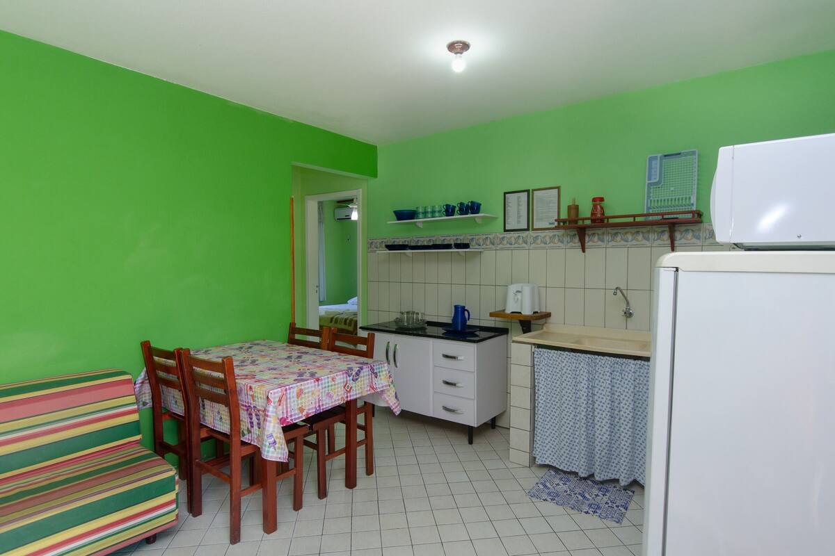 Une cuisine de taille réduite comprenant une table à manger, des chaises, un réfrigérateur et un four à micro-ondes.