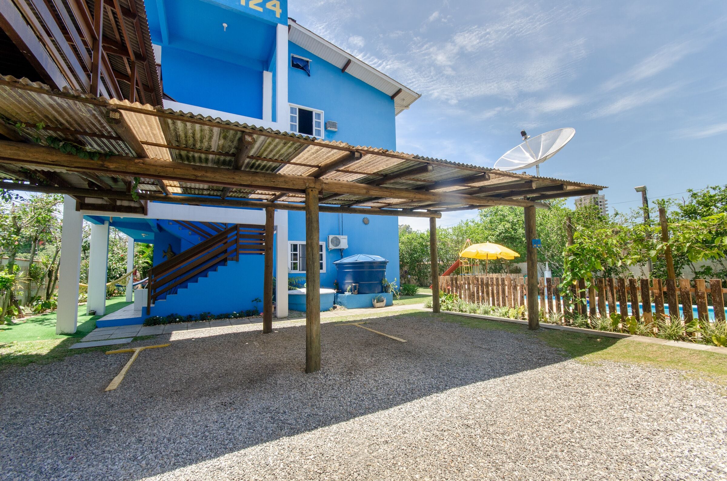 A blue building with a satellite dish, a covered outdoor area, and a playground.
