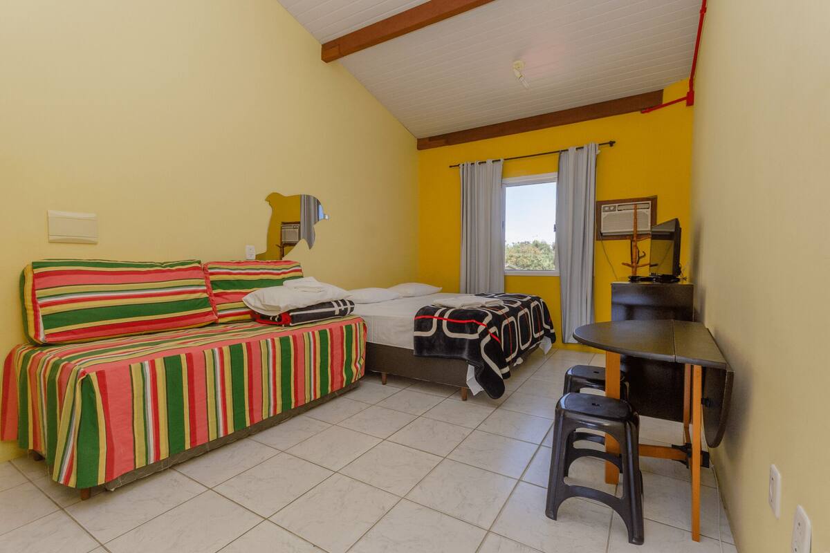 Une petite chambre avec deux lits, une petite table et une chaise.