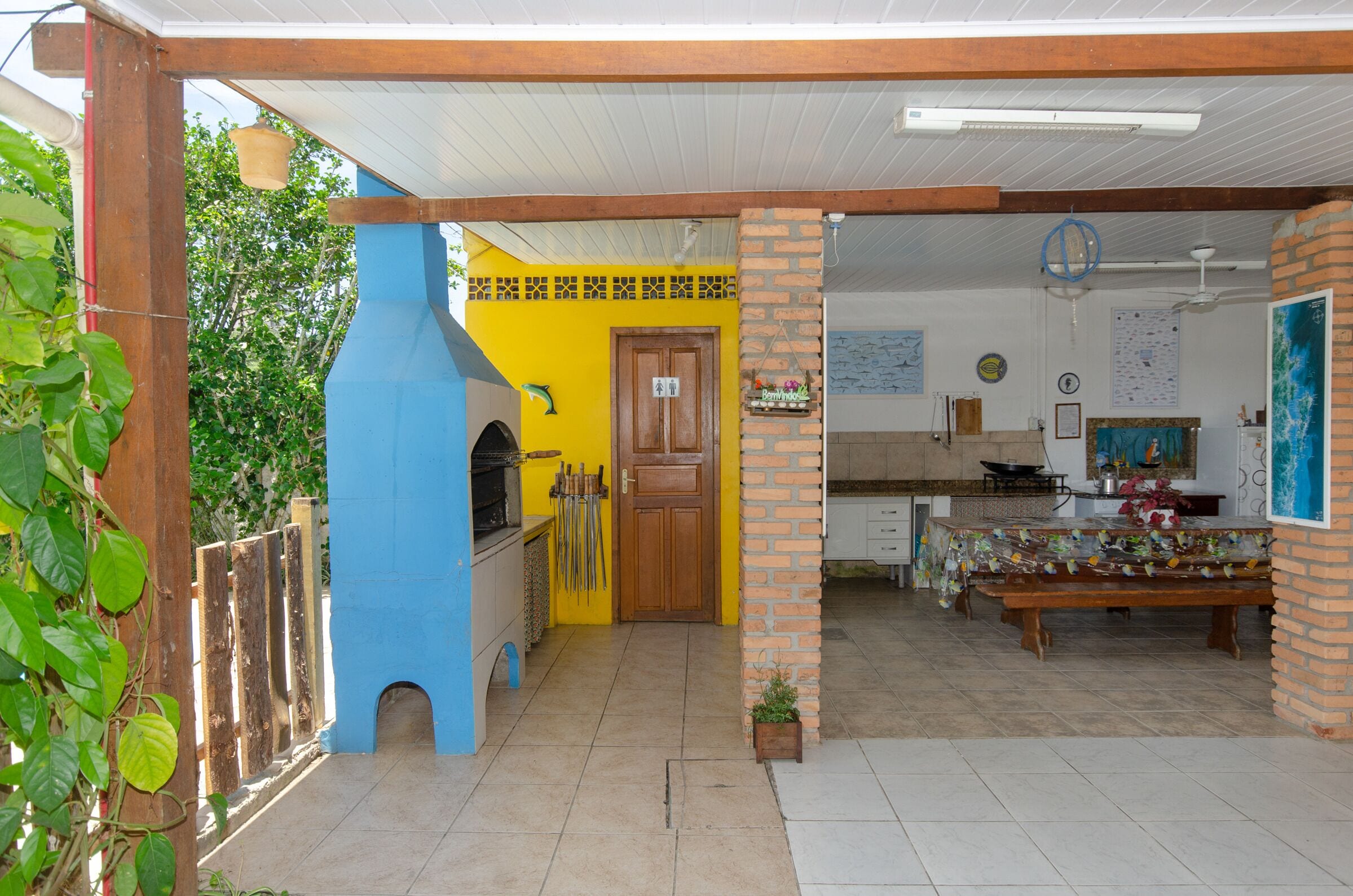 Una cocina con decoración azul y amarilla, una puerta de madera y un pilar de ladrillo.